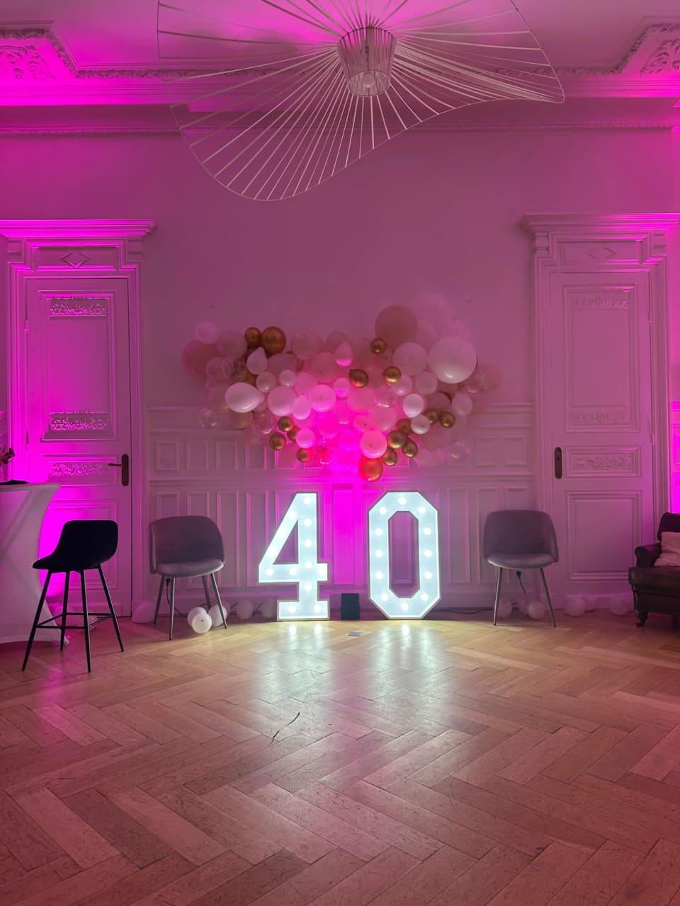 Salon éclairé en rose avec chiffres lumineux et ballons