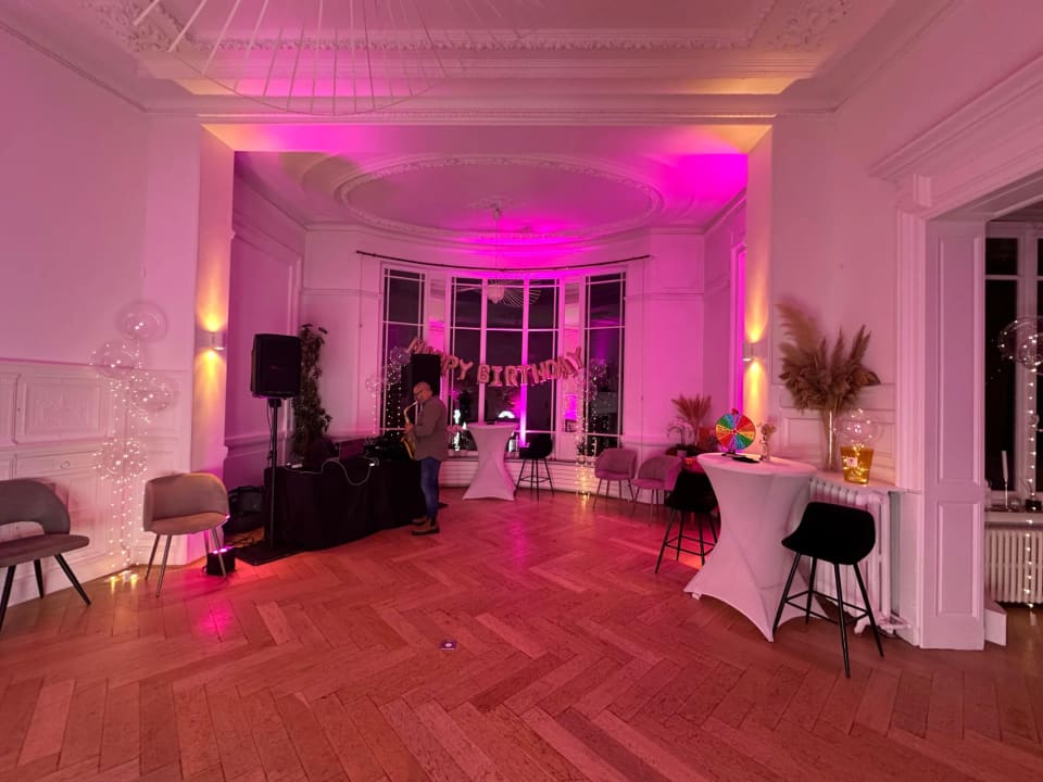 Grand salon mis en lumière rose pour une soirée d'anniversaire