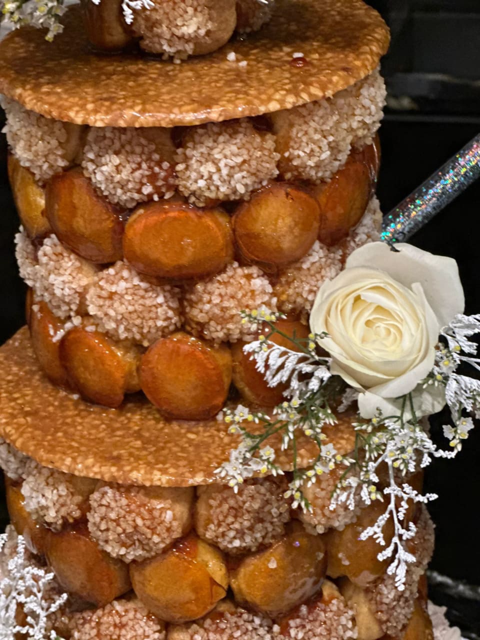 Pièce montée en choux et nougatine décorée d'une rose blanche
