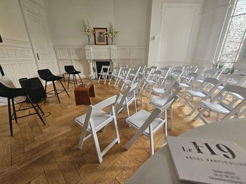 Salle de conférence du 119 aménagée de chaises blanches pour un séminaire