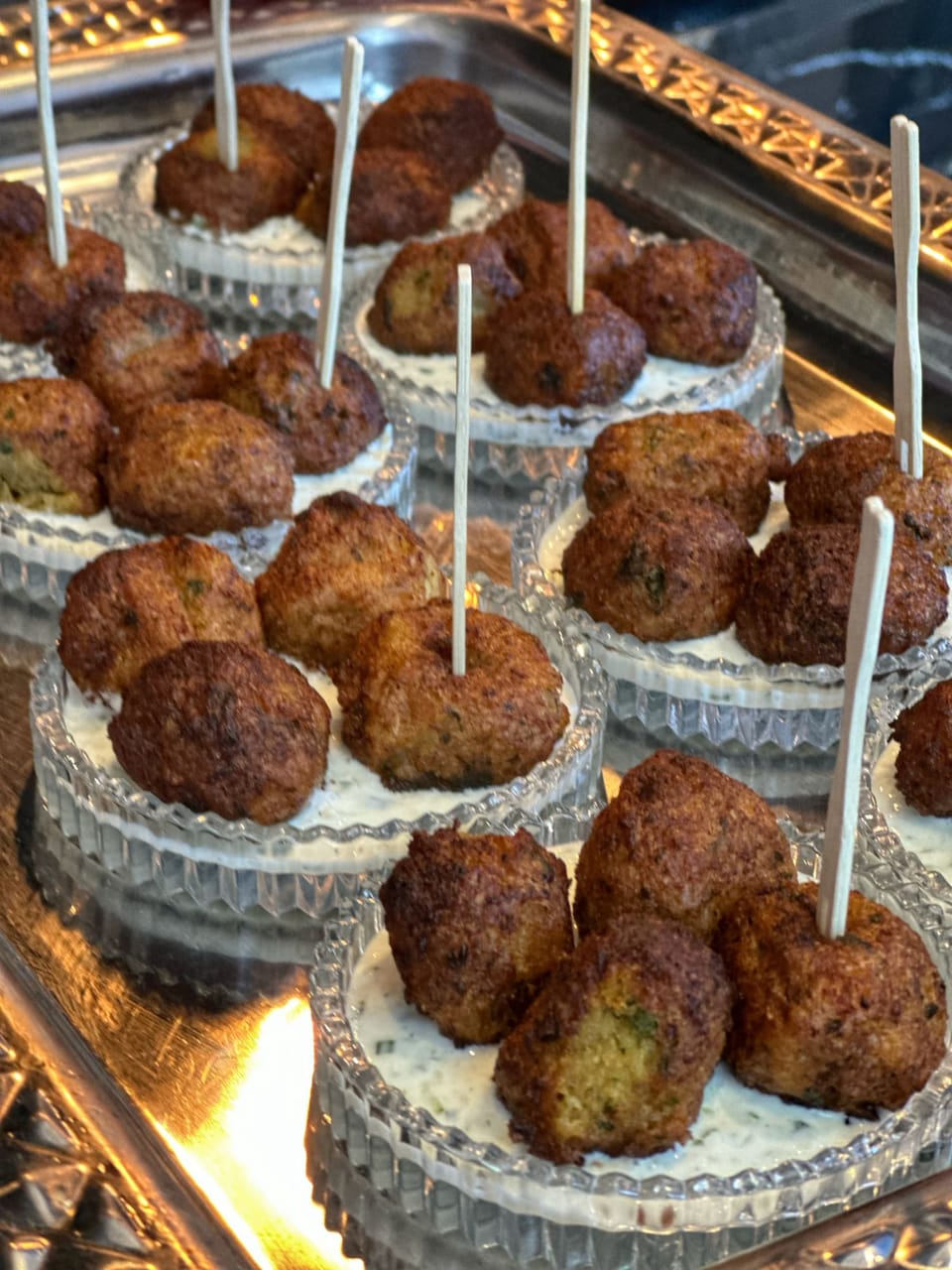 Bouchées dorées et sauce fraîche servies en coupelles de cristal sur un plateau argenté, pour le cocktail