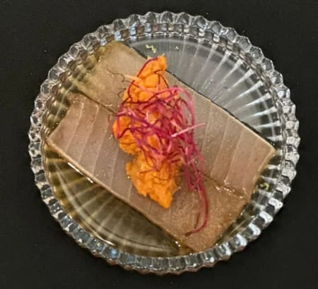 Tranche de terrine de poisson garnie de pousses de betterave
