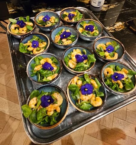Mini salades de crevettes et fleurs comestibles en coupelles
