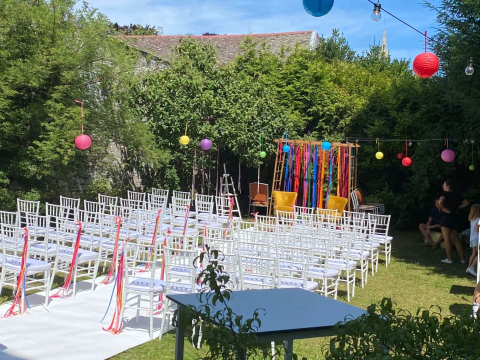 Cérémonie colorée dans le jardin du 119, chaises blanches, rubans et lampions