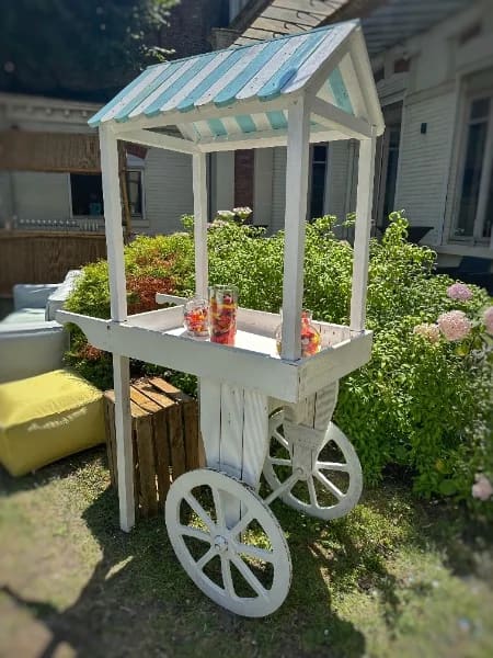 Charrette à bonbons installée dans le jardin pour un mariage