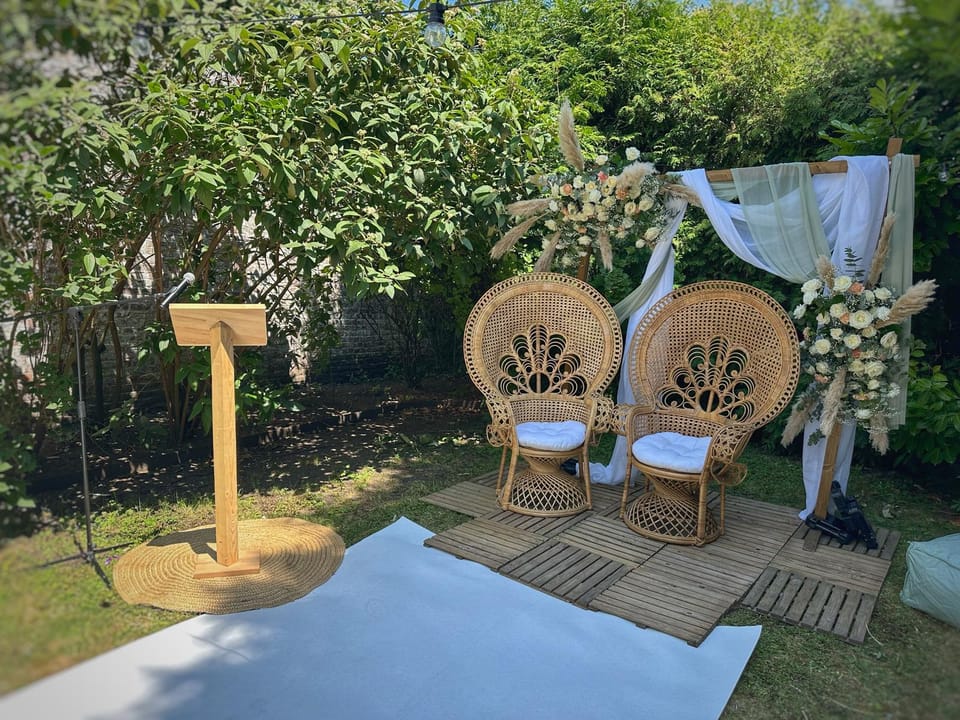 Cérémonie dans le jardin du 119 à Valenciennes : fauteuils en rotin, arche fleurie et pupitre en bois