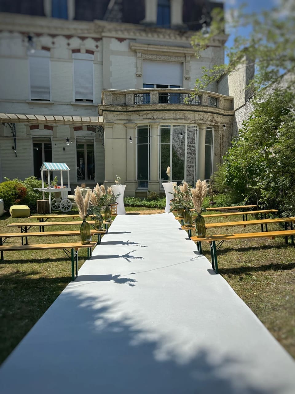 Allée blanche et bancs dressés dans le jardin de l'hôtel particulier Le 119, prêts pour la cérémonie