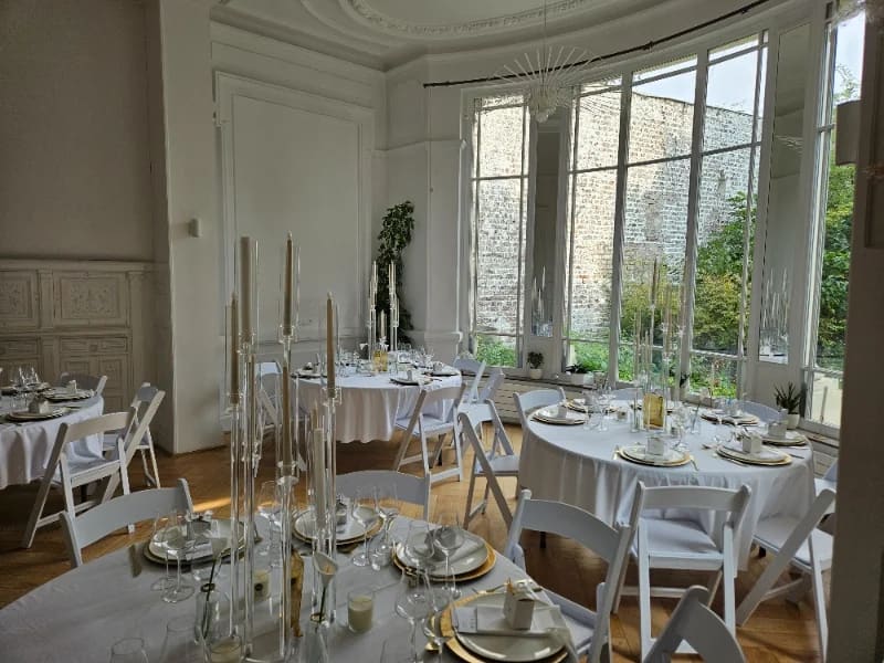 Salon en rotonde dressé de tables rondes et chandeliers