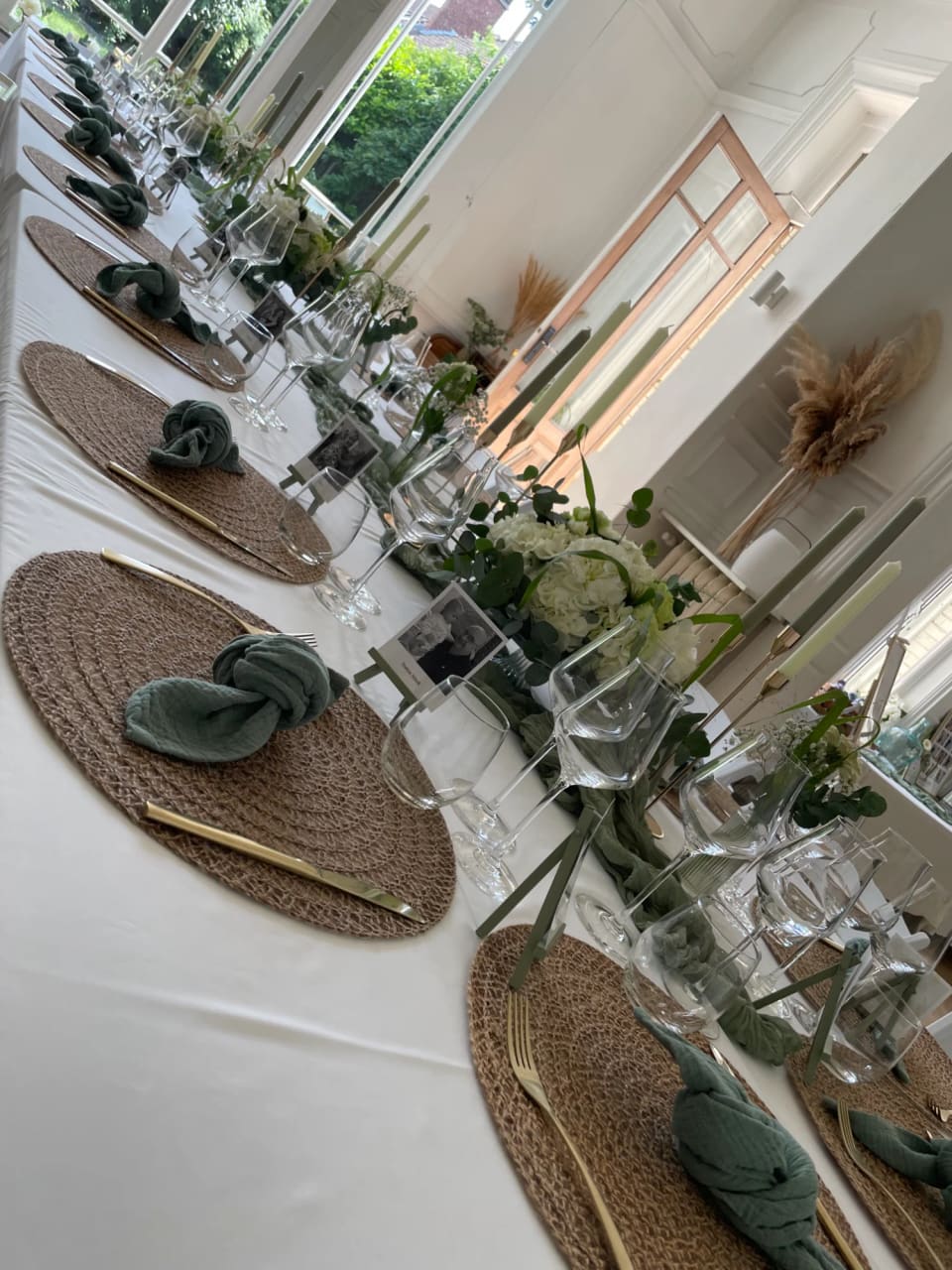 Table de banquet aux sets en osier et serviettes vertes