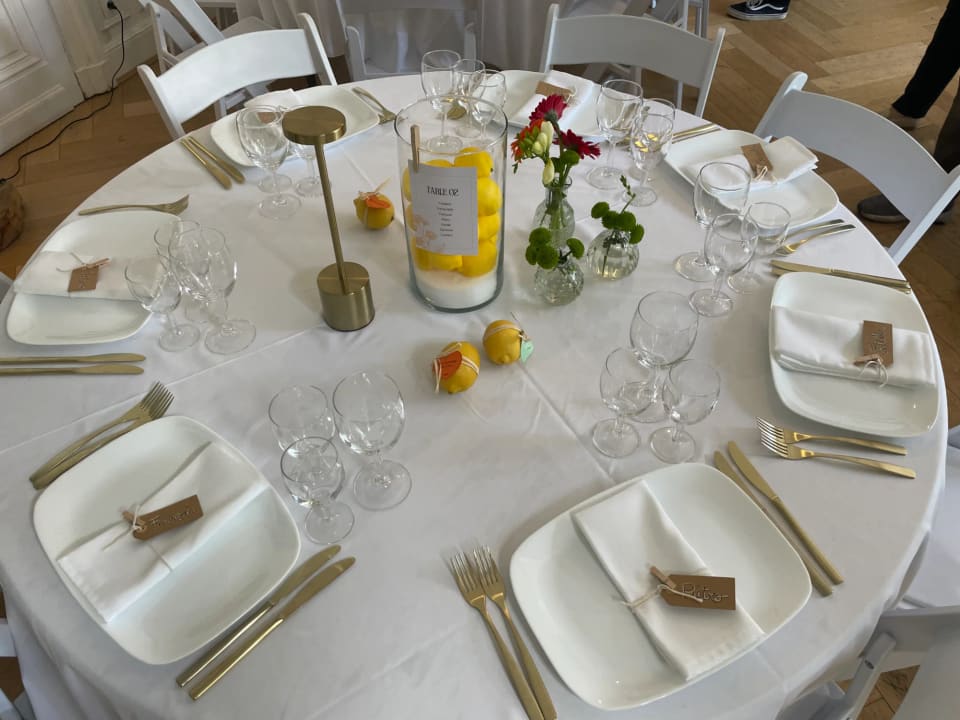 Table ronde dressée vue du dessus, centre de table aux citrons et fleurs