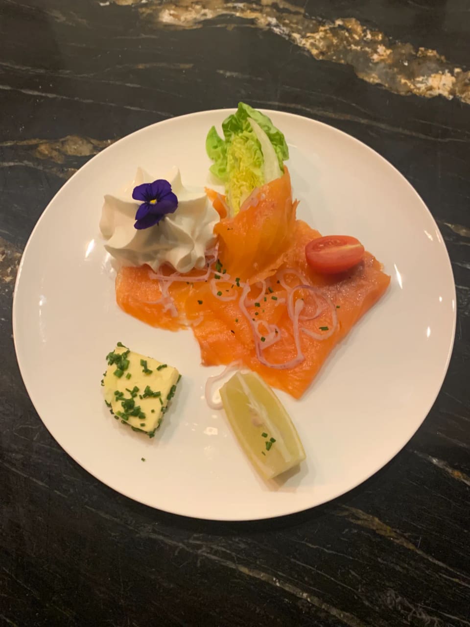 Assiette de saumon fumé, beurre aux herbes et fleurs comestibles