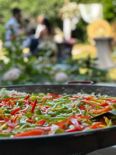 Paëlla aux poivrons colorés préparée dans le jardin pendant la réception