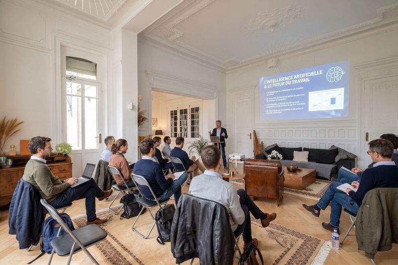 Conférencier présentant « L'intelligence artificielle et le futur du travail » à un public de professionnels assis dans le grand salon du 119