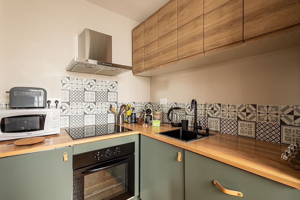 Cuisine équipée avec four, hotte et plan de travail en bois, appartement #3 du 119