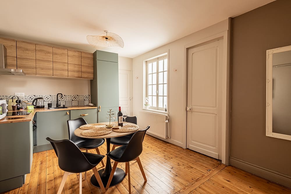 Cuisine vert sauge avec table ronde et chaises noires, appartement #3 du 119