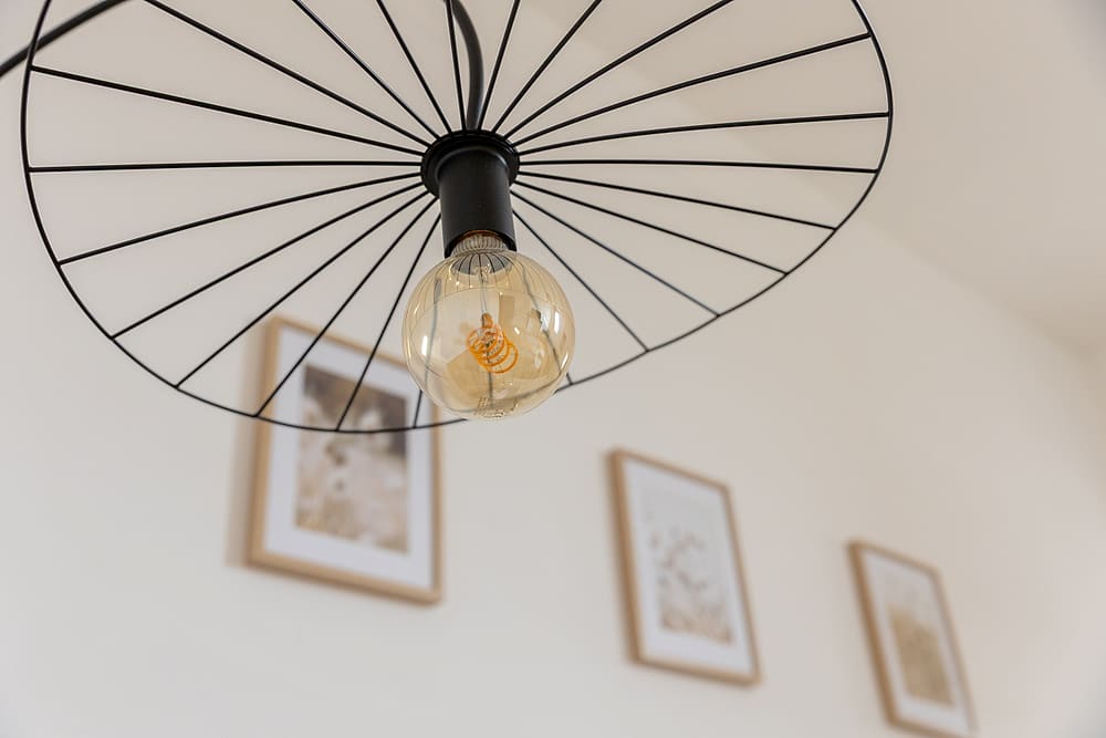 Détail de décoration : suspension en métal et cadres, appartement #3 du 119
