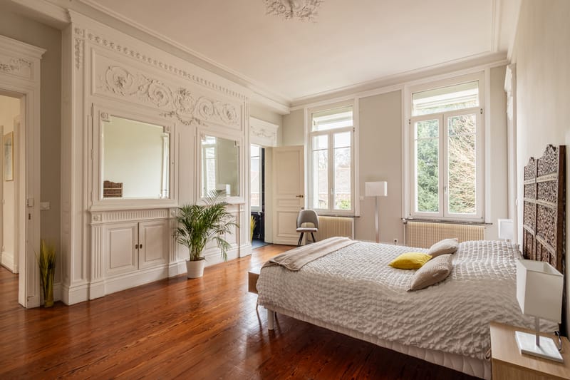 Chambre d'un appartement de l'hôtel particulier Le 119, plafond mouluré, grandes fenêtres et parquet ancien