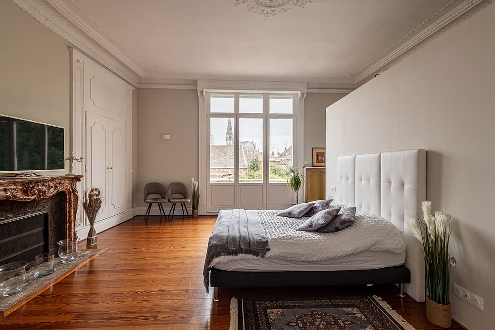 Chambre principale, lit double et cheminée en marbre, appartement Prestige #1 du 119 à Valenciennes