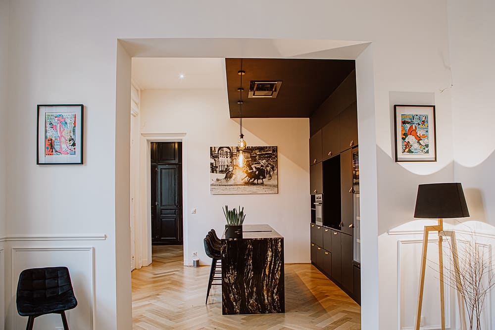 Cuisine de l'appartement Prestige #1 du 119 à Valenciennes : îlot en marbre, tabourets et rangements noirs