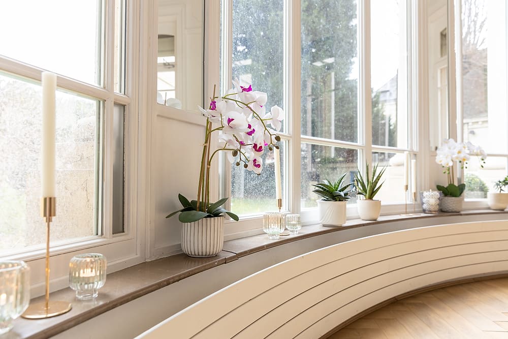 Détail du bow window du salon : orchidées et vue sur le jardin, appartement Prestige #1 du 119