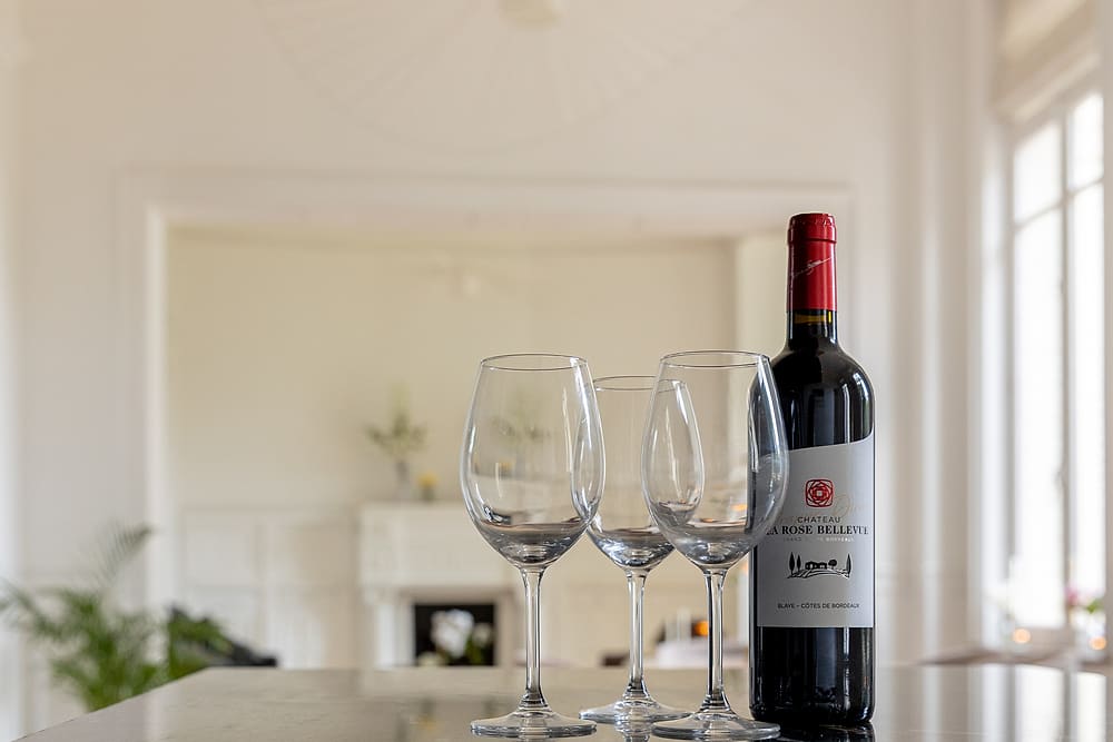 Détail de la cuisine : verres à vin et bouteille sur le plan de travail en marbre