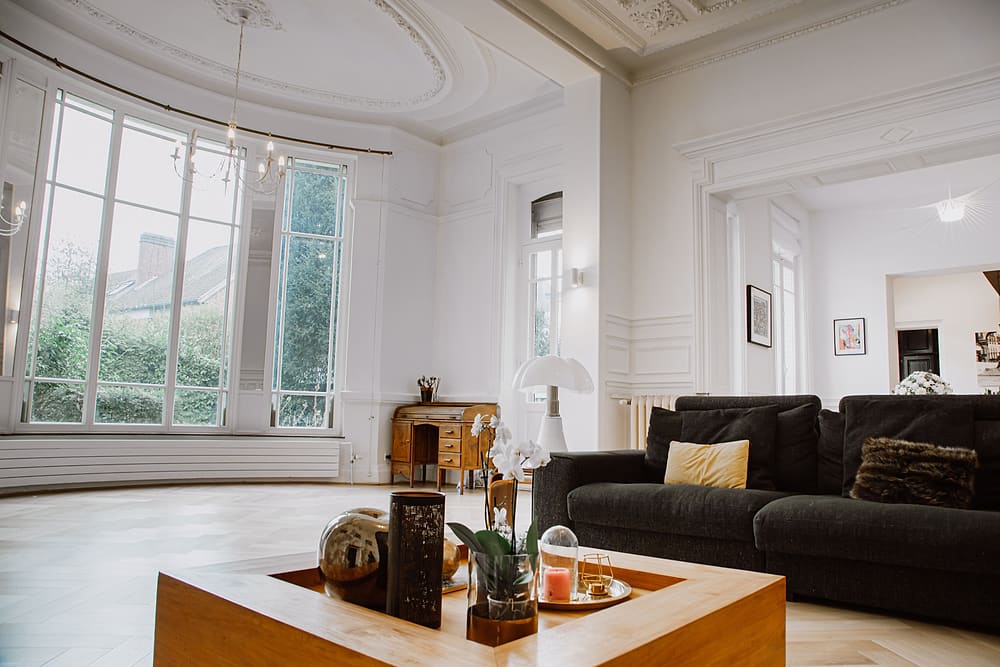 Salon lumineux avec grandes baies vitrées sur le jardin, canapé et table basse en bois, appartement Prestige #1 du 119