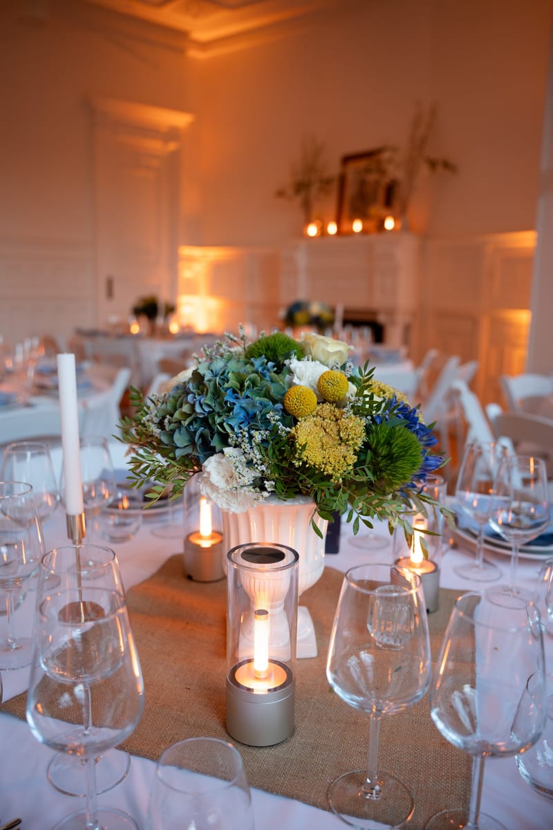 Centre de table en hortensias et craspedias dans une urne blanche