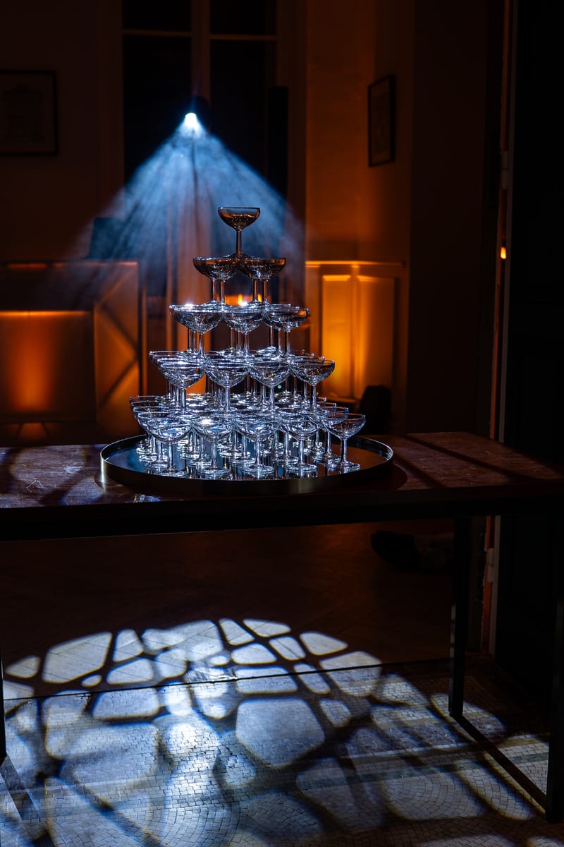 Pyramide de coupes de champagne éclairée par un projecteur lors d'une soirée