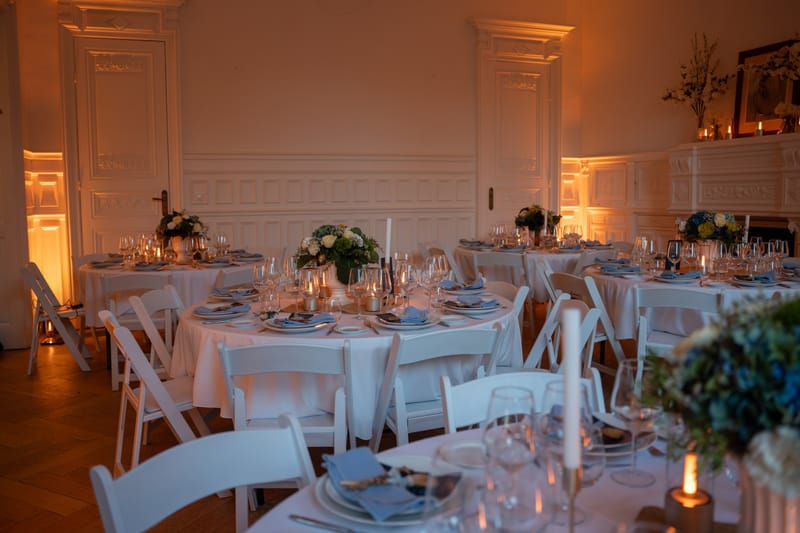 Salon du 119 aux tables dressées, sous un éclairage ambré, pour une réception de mariage