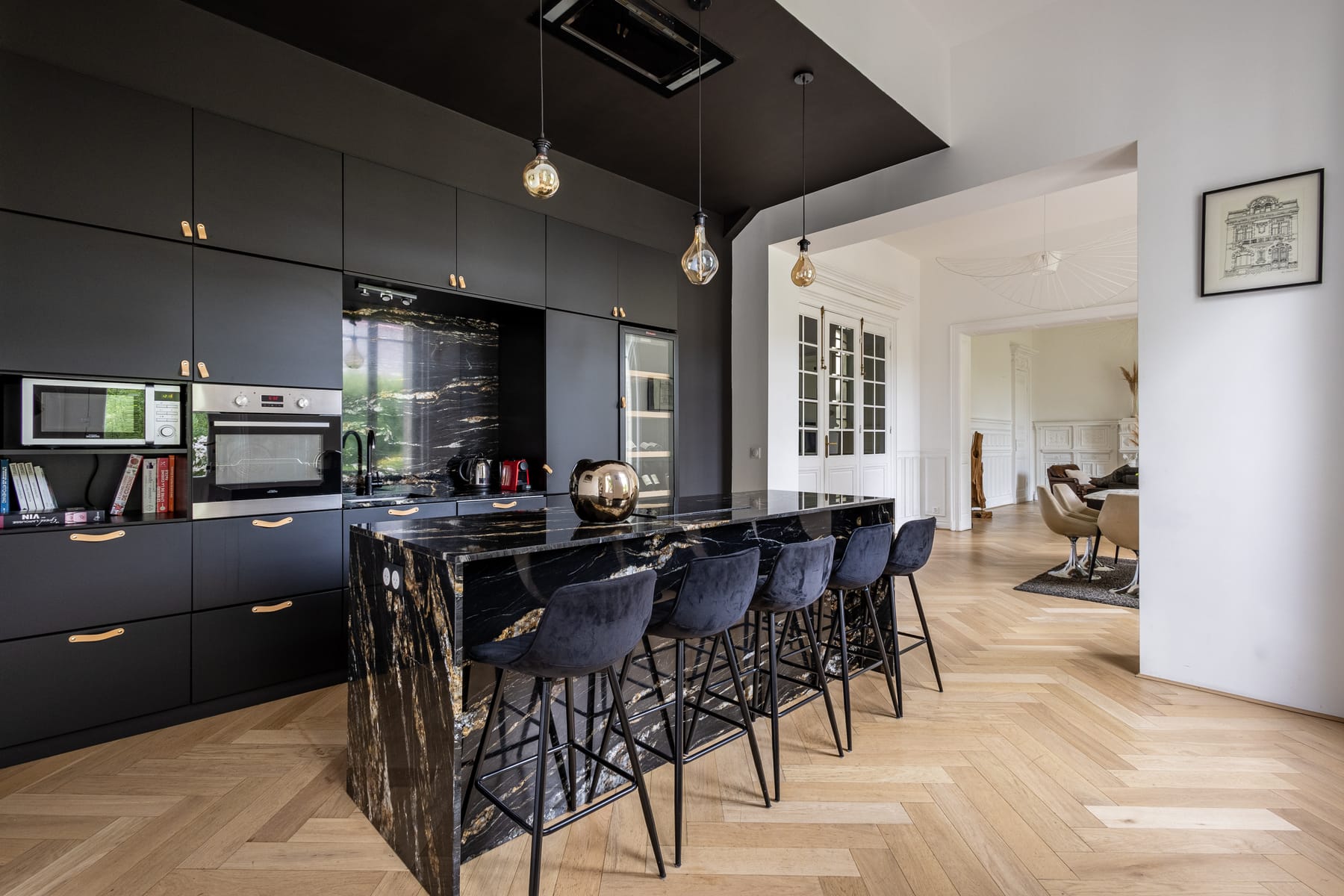 Cuisine contemporaine du 119, îlot central en marbre noir veiné d'or, ouverte sur les salons
